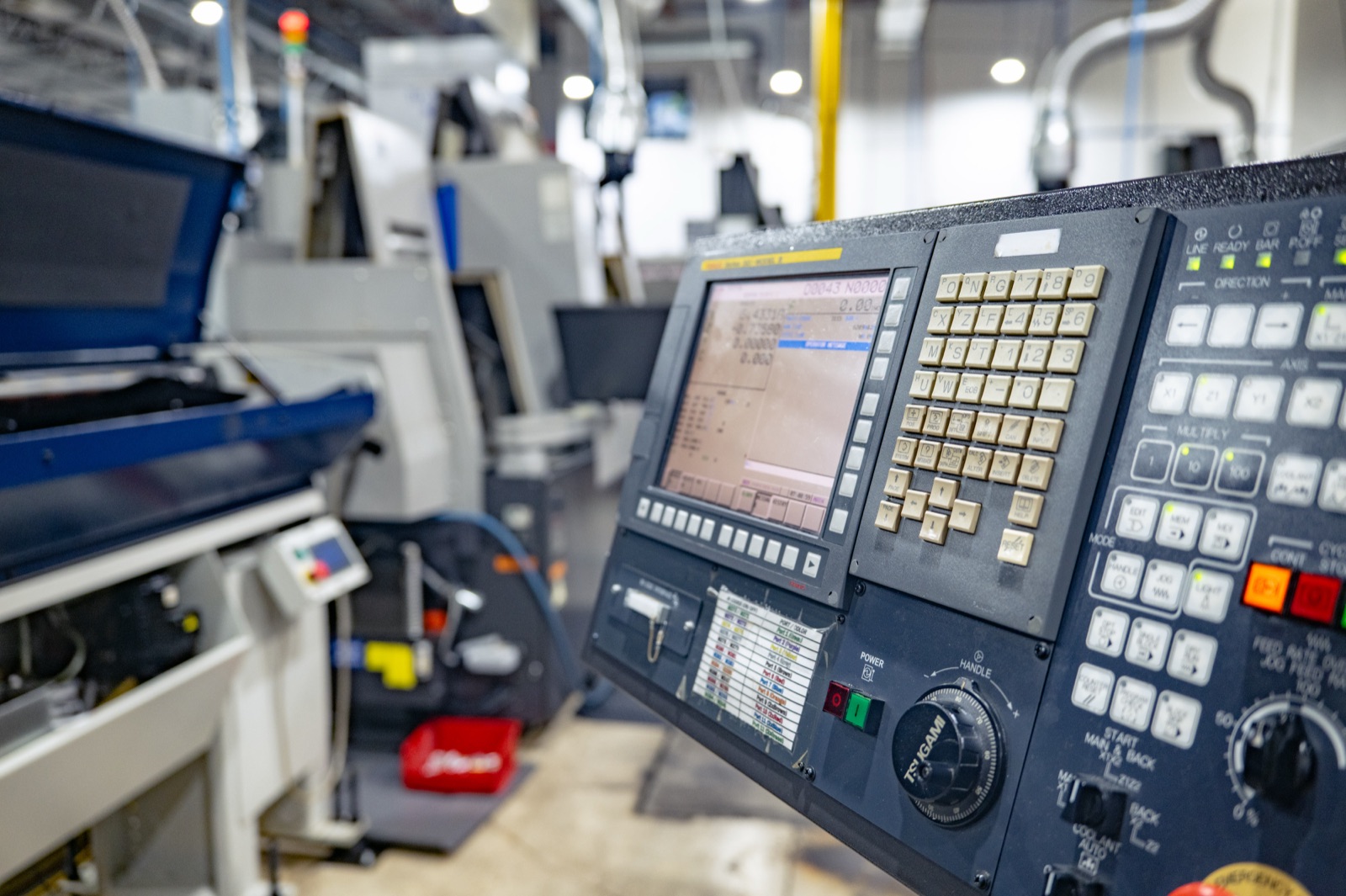Machinist programming a CNC machine at the Mazak Smooth control panel