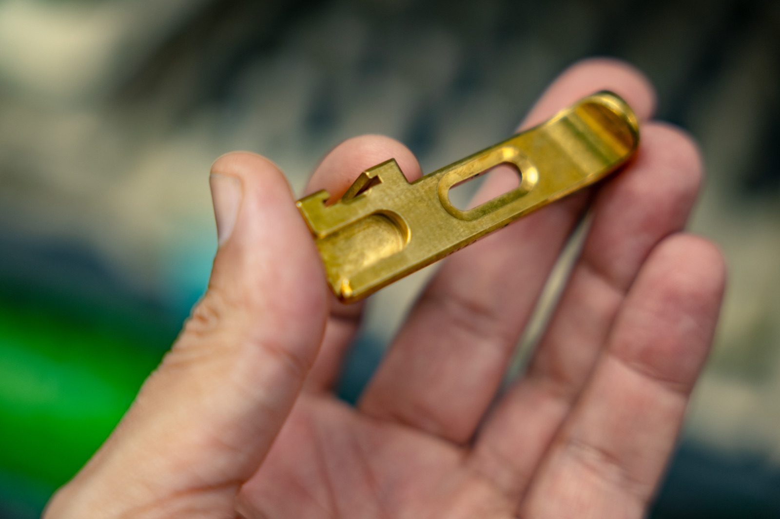 Precision machined brass part held in hand
