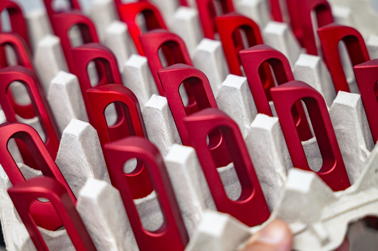 Red anodized aluminum parts on an anodizing rack