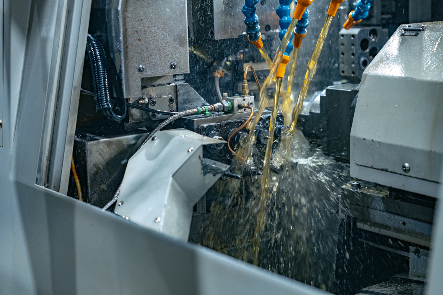Coolant flooding the cutting tools inside a CNC Swiss lathe during a turning cycle